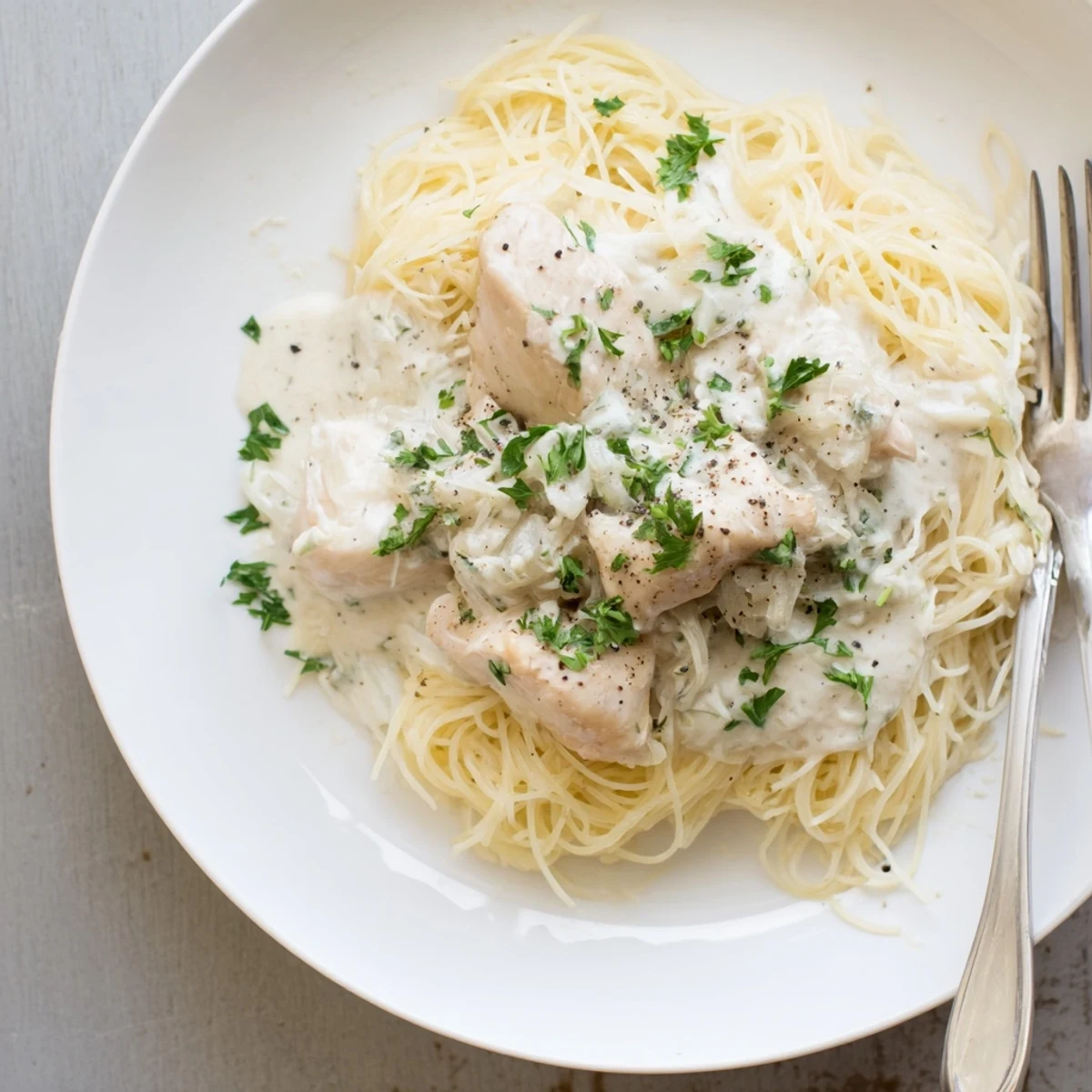 Creamy Crock Pot Angel Chicken served over angel hair pasta with golden sauce
