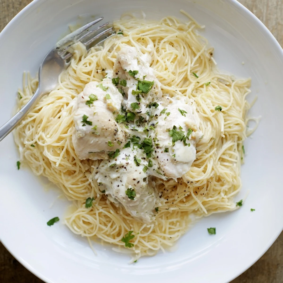 Tender slow-cooked chicken breasts in rich cream cheese sauce over pasta