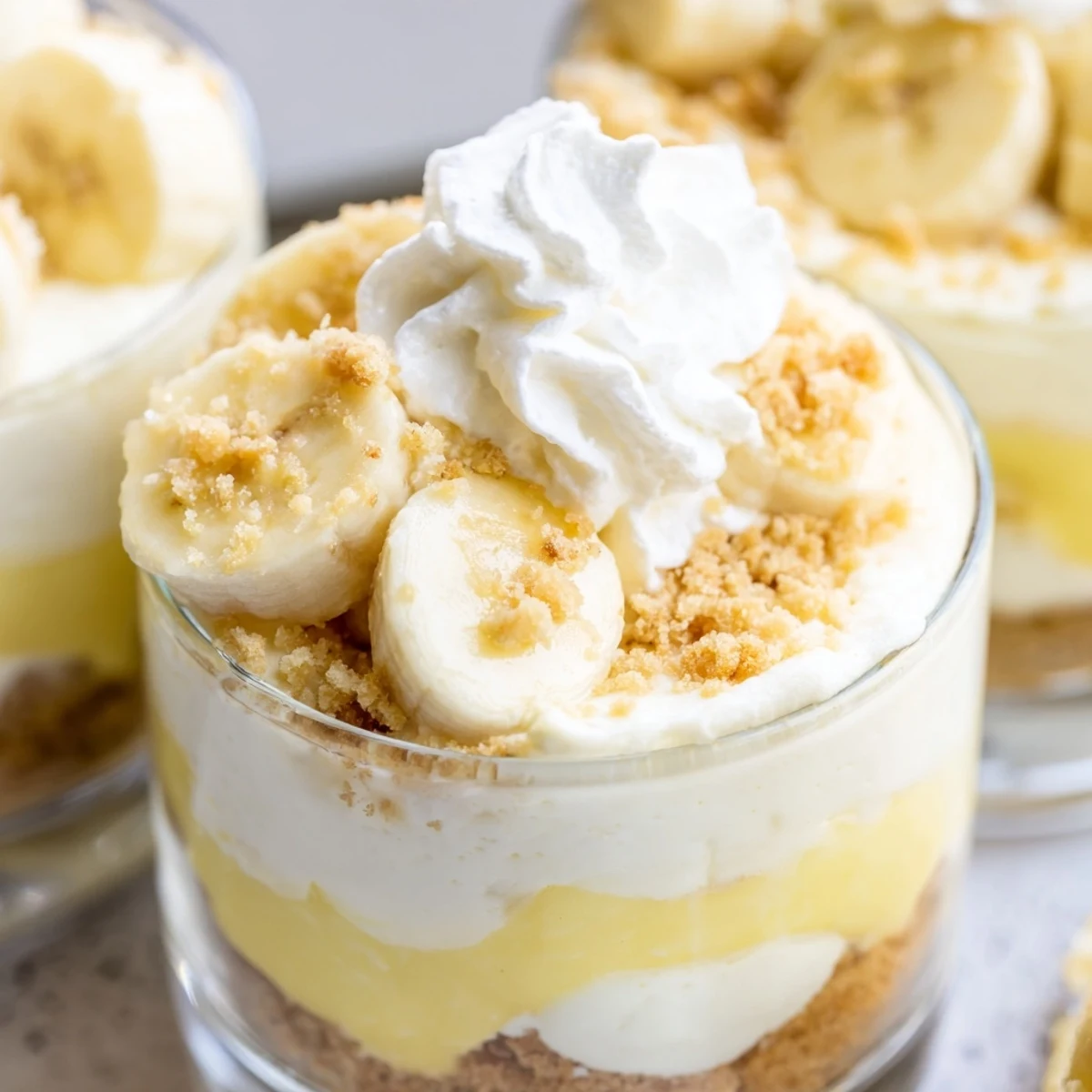 Golden vanilla wafer crust beneath layers of banana pudding cheesecake with fresh sliced banana topping