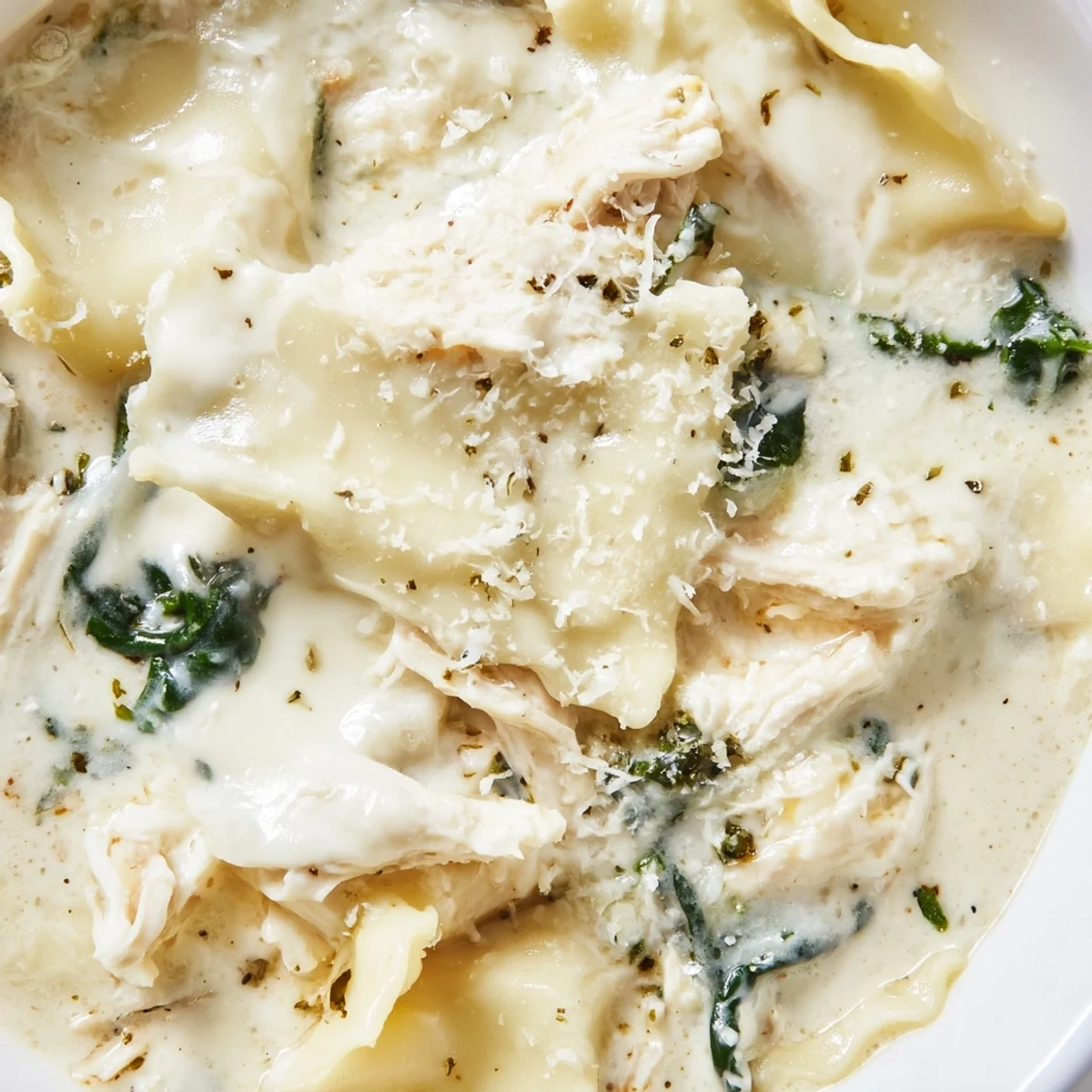 Creamy white lasagna soup in a white bowl with melted cheese and tender noodles