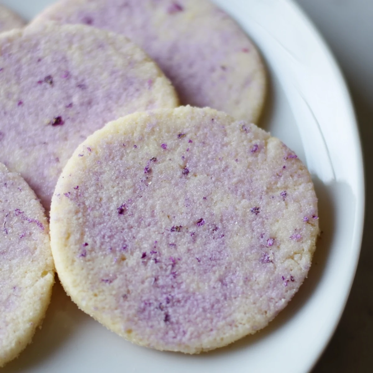 Soft lilac sugar cookies with pale purple edges cooling on a wire rack