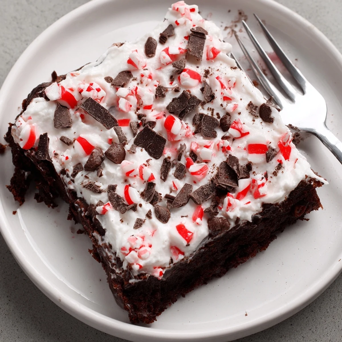 Peppermint Poke Cake with glossy mint pudding, fluffy whipped topping, crushed candies