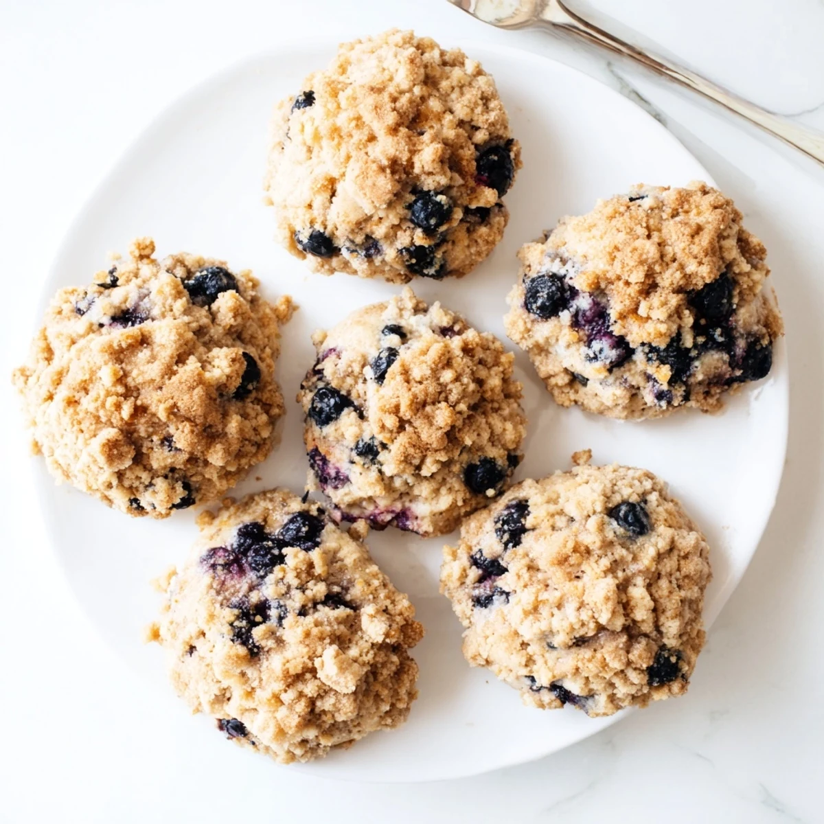 Homemade blueberry muffin cookies with crumbly streusel cooling on a wire rack