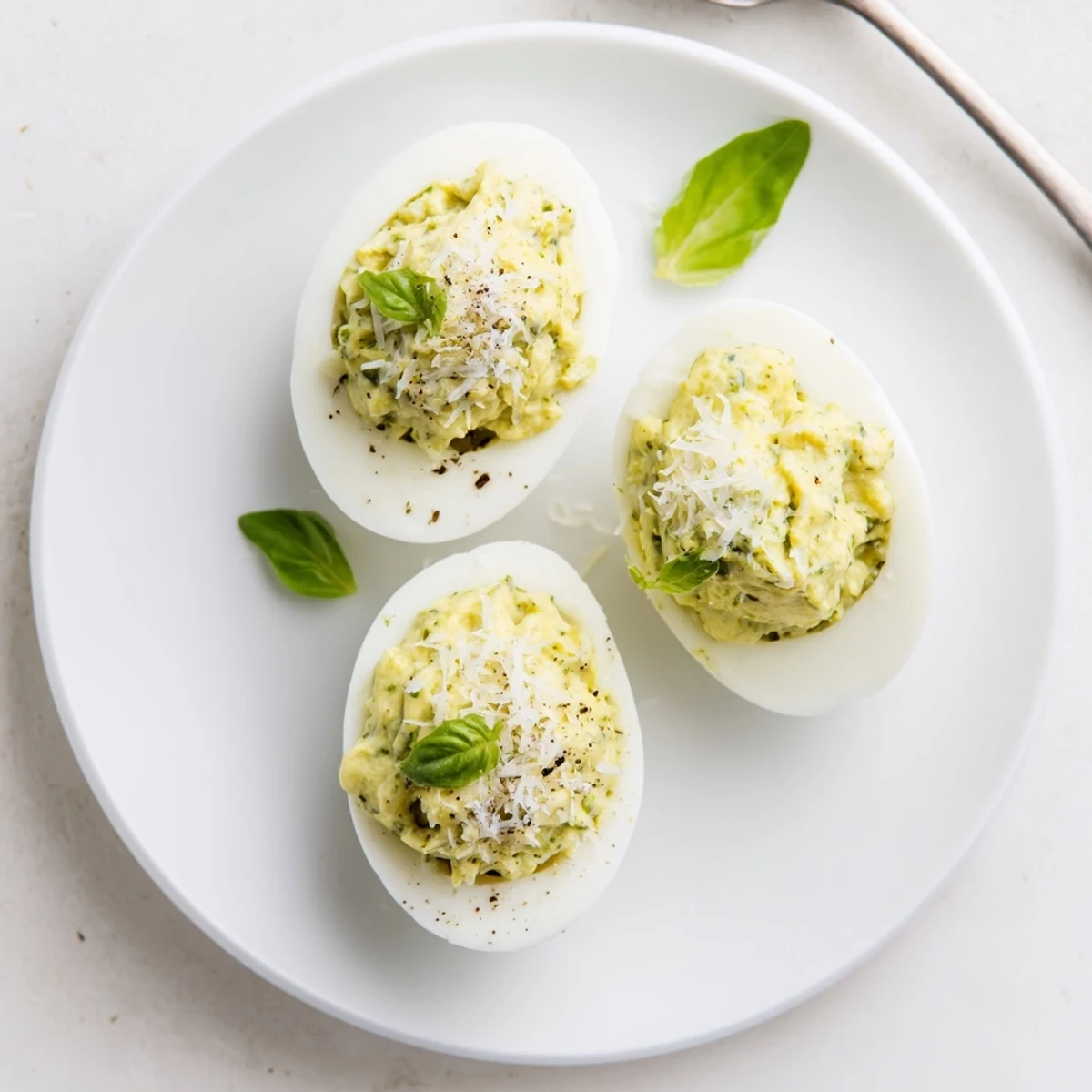 Bright Pesto Parmesan Deviled Eggs, silky yolk filling piped onto whites