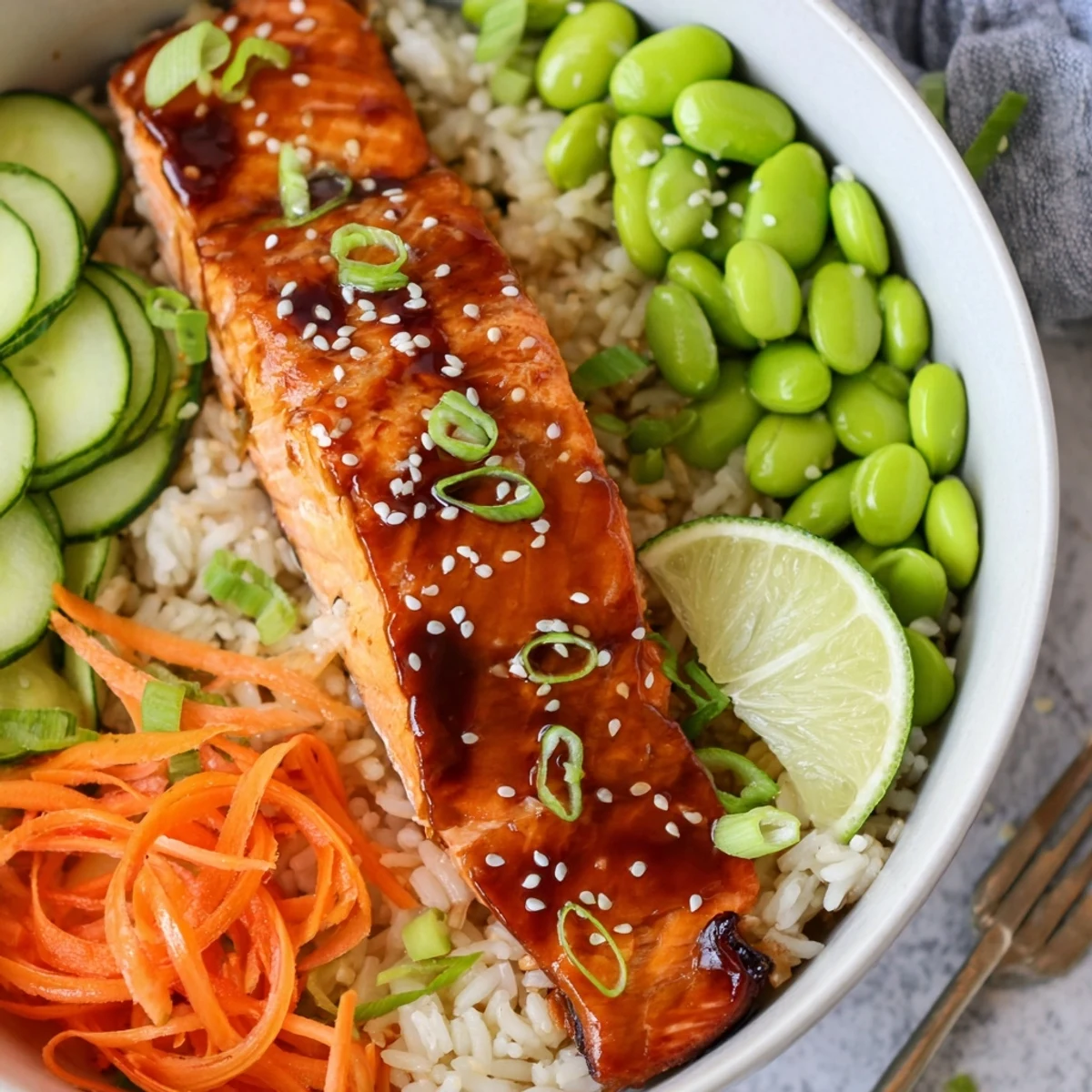 A Honey Glazed Salmon Bowl served warm, topped with creamy avocado and lime