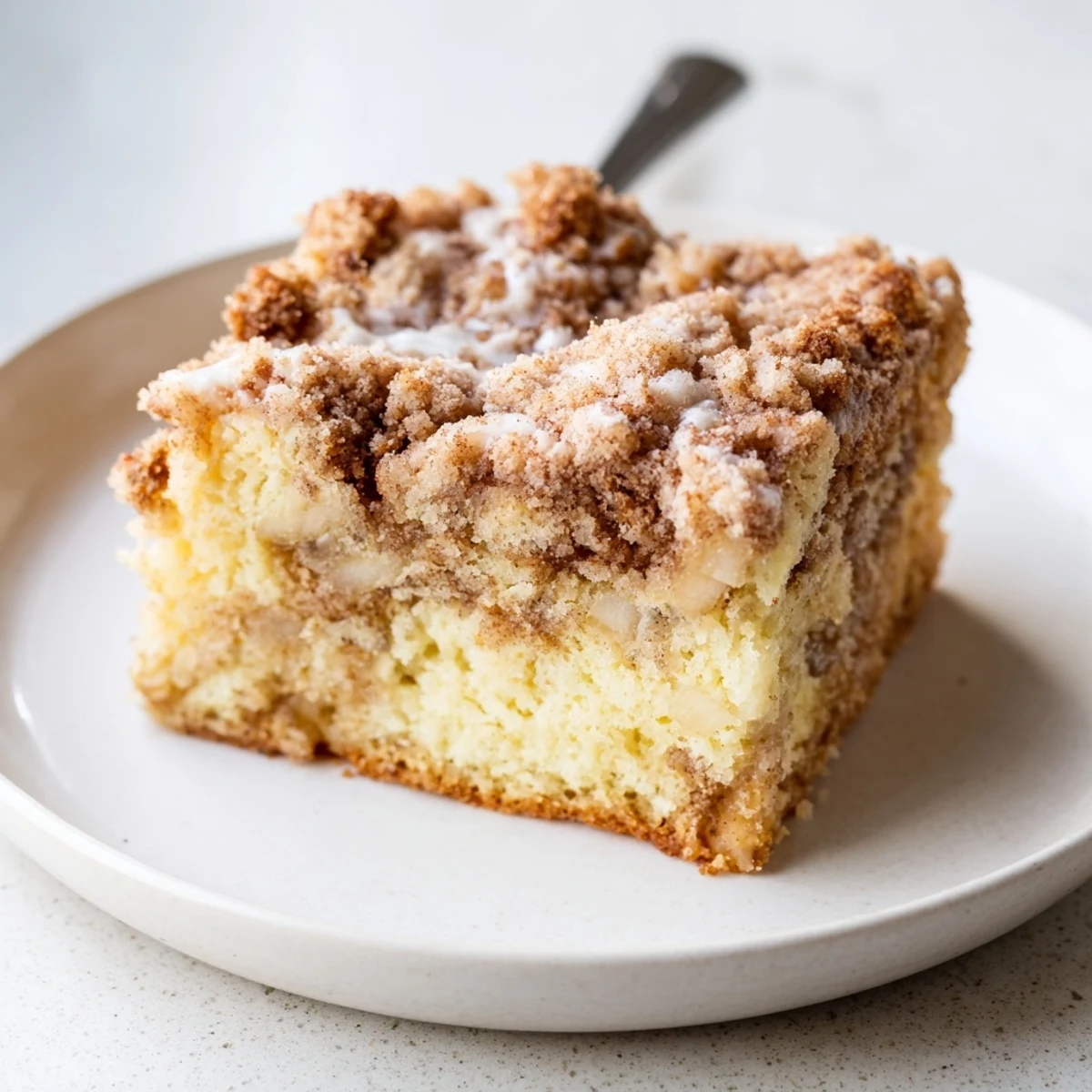 Serve Banana Crumb Coffee Cake warm with coffee and powdered sugar dusting