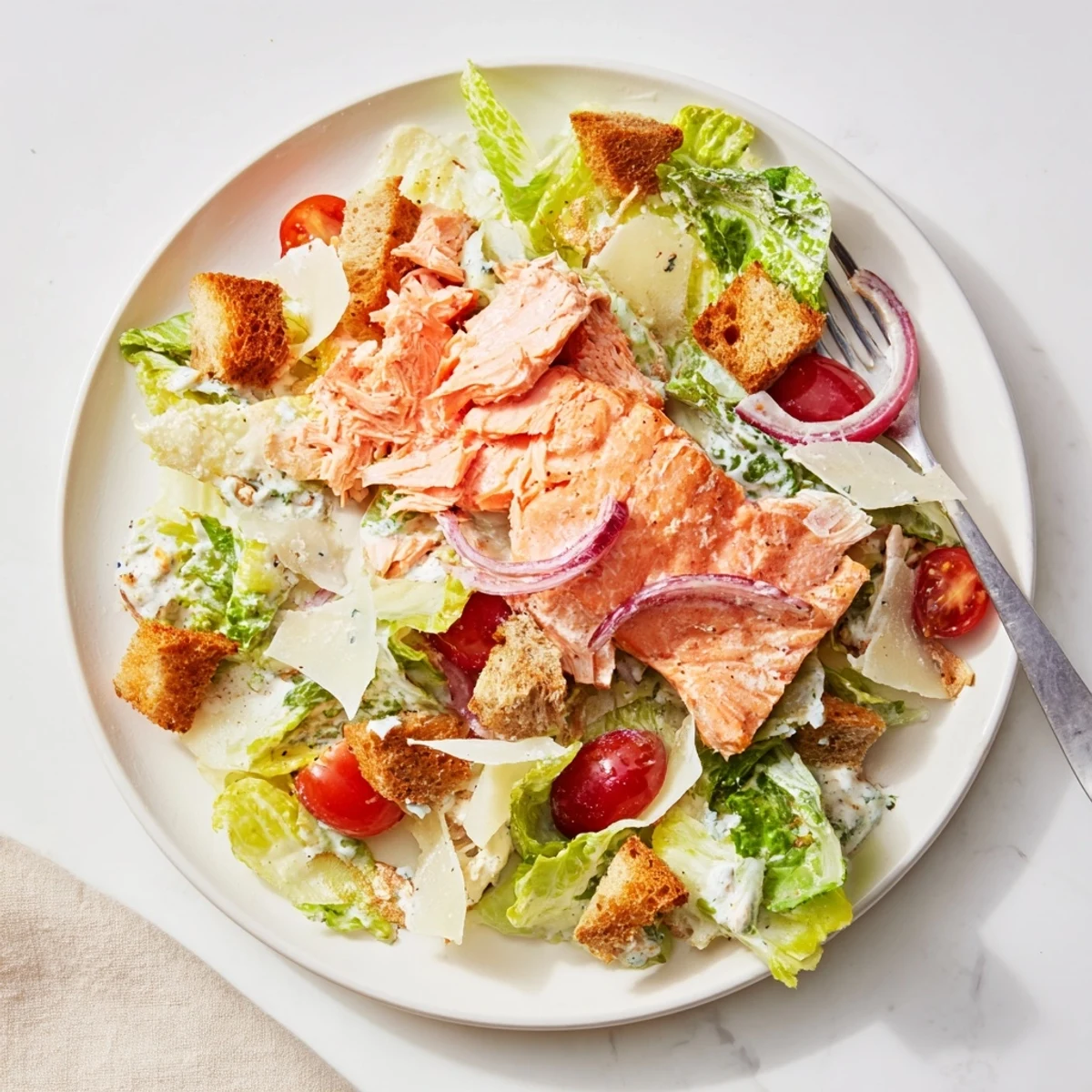 Bowl of Smoky Salmon Caesar Salad topped with shaved Parmesan and croutons