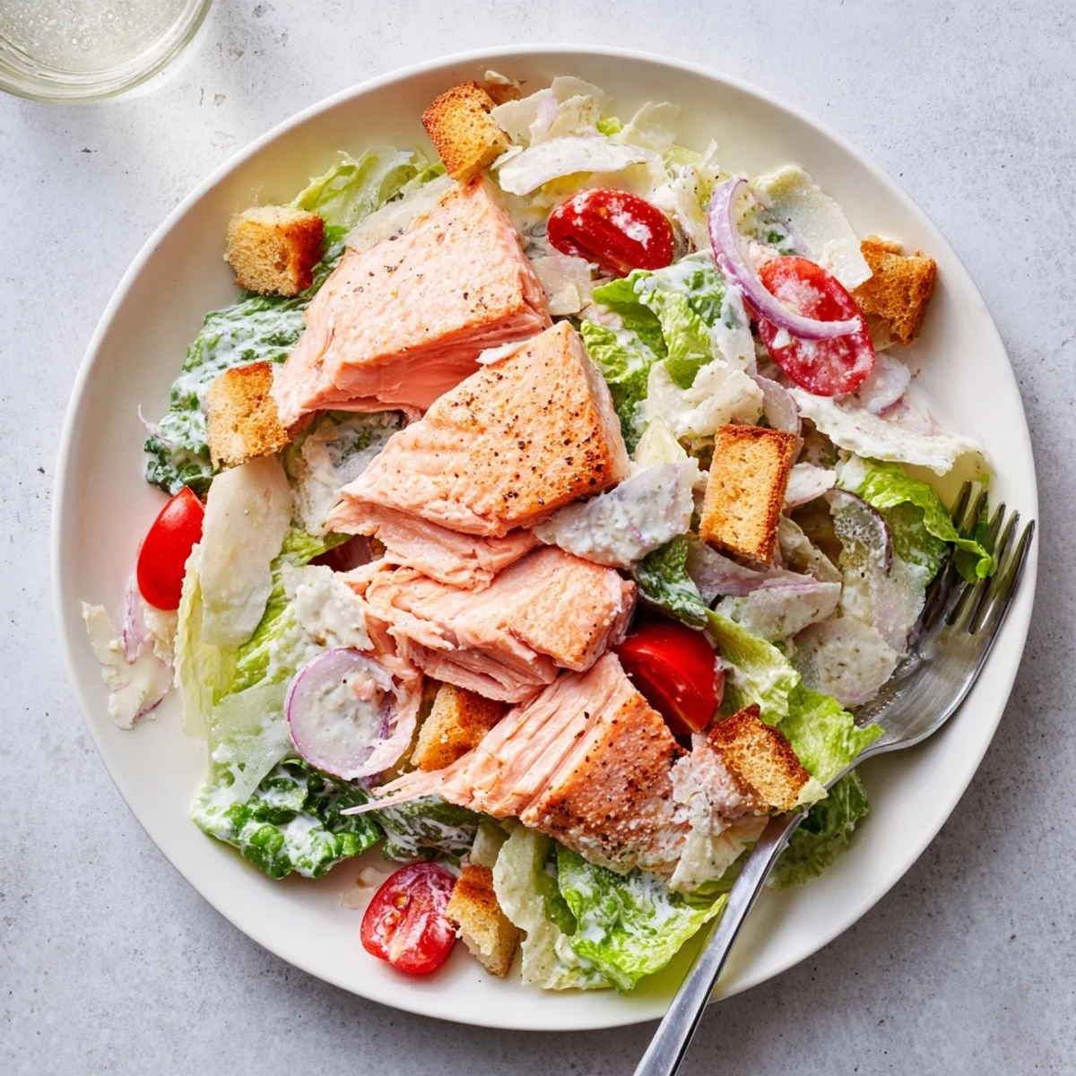 Bright Smoky Salmon Caesar Salad served with lemon wedge, anchovy-kissed creamy dressing