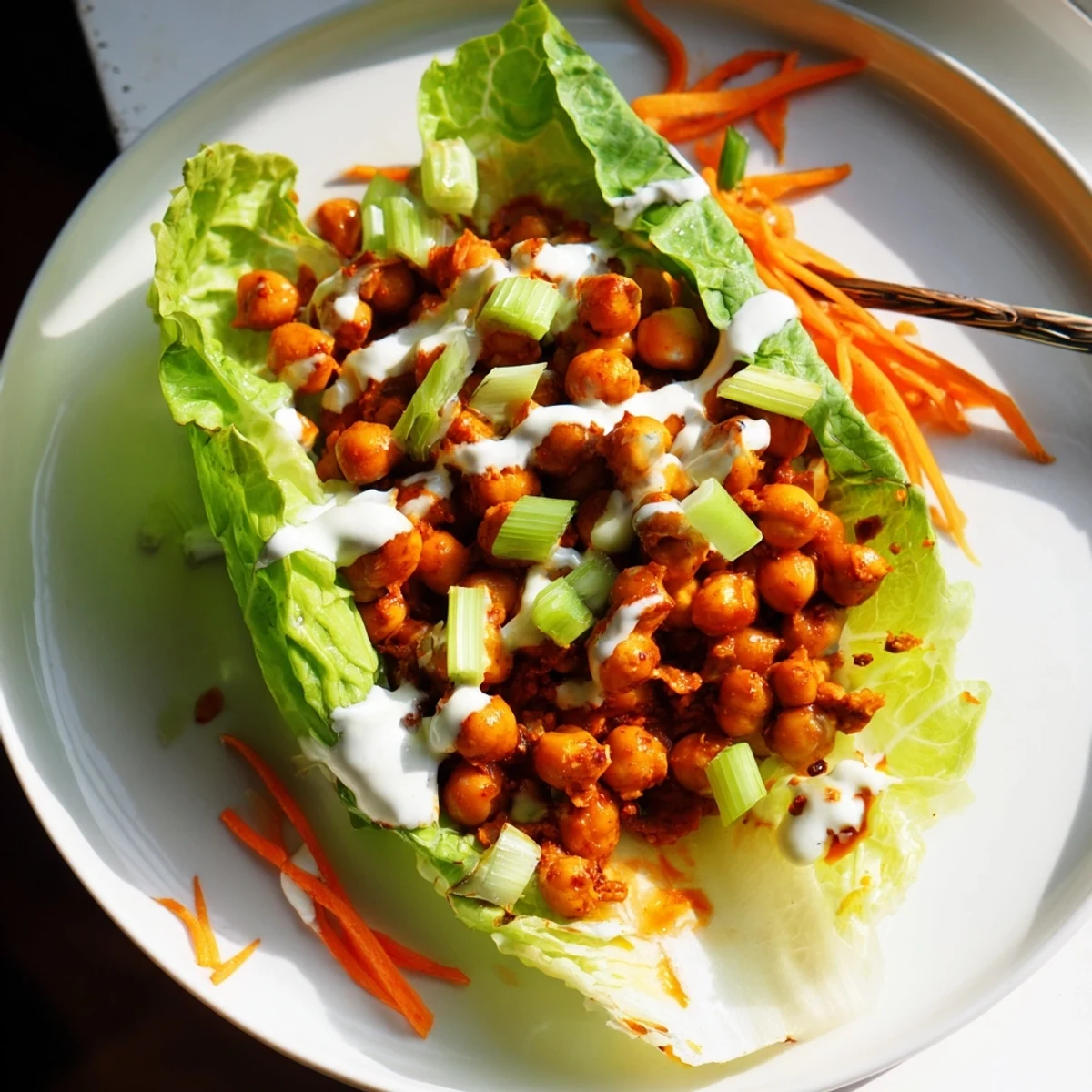 Buffalo Chickpea Lettuce Wraps piled on a platter, spicy chickpeas and creamy ranch  