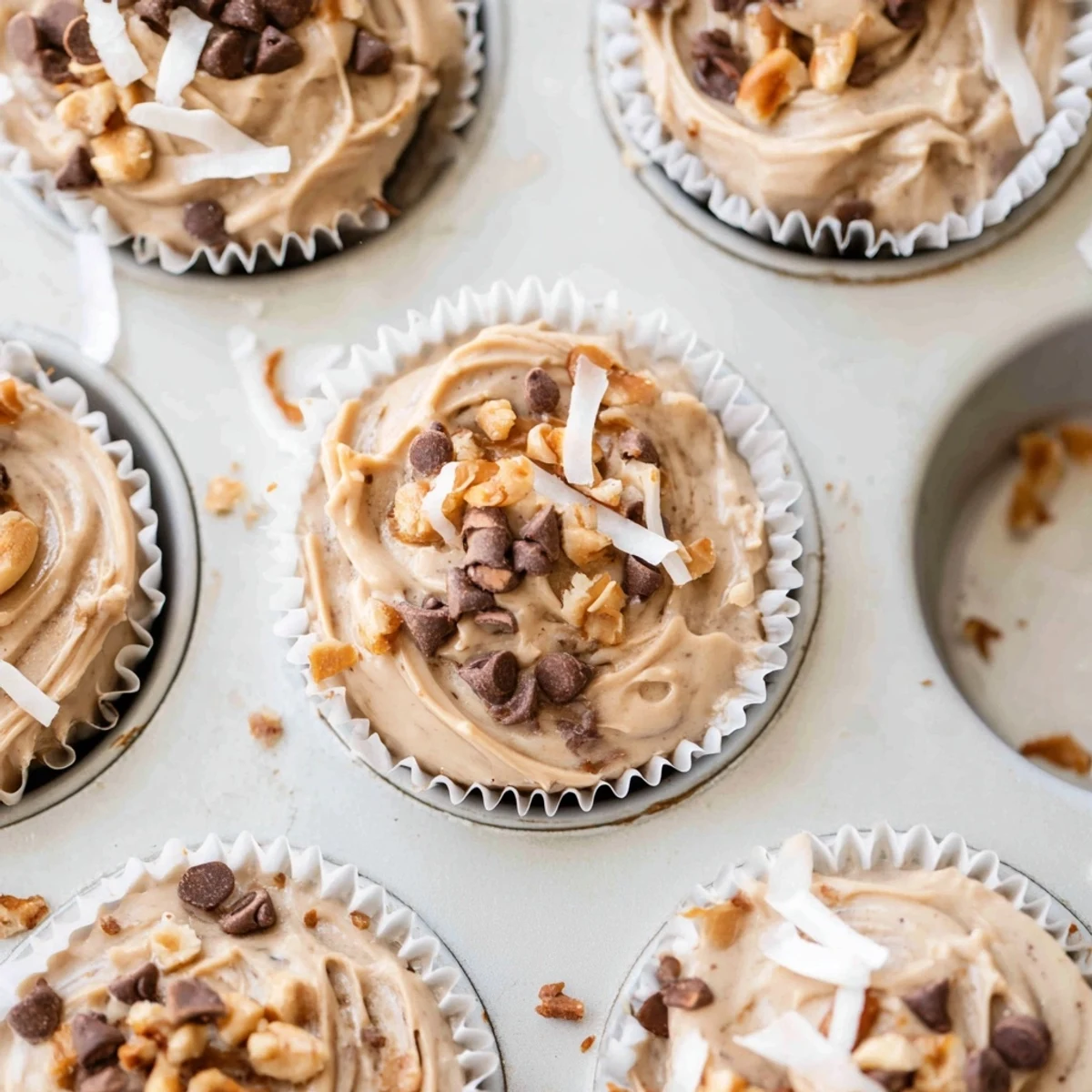 Creamy frozen peanut butter Greek yogurt bites sprinkled with chopped roasted peanuts on a white plate