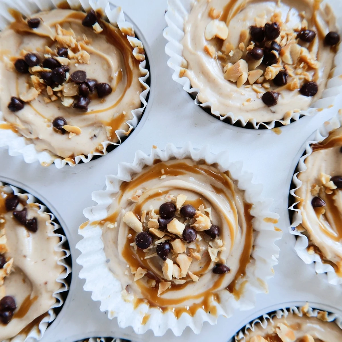 Protein-packed frozen peanut butter Greek yogurt bites arranged on a dark surface with coconut flakes
