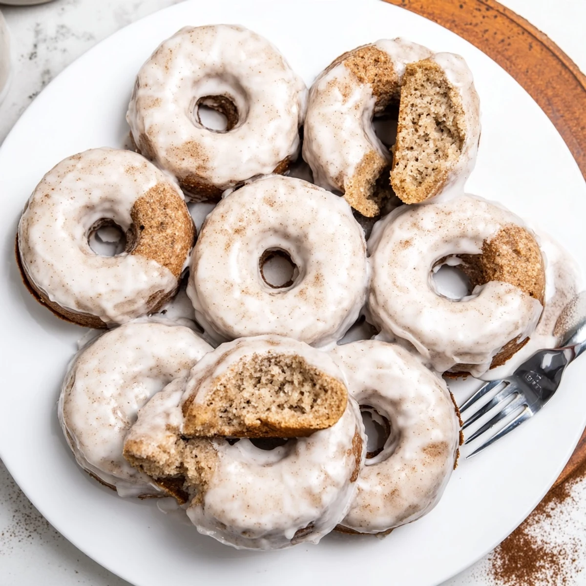 Moist baked donuts topped with powdered sugar glaze and ripe banana speckles