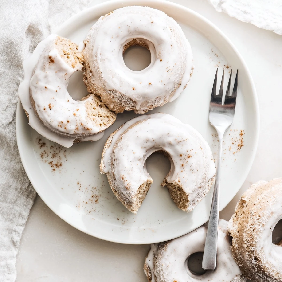 Cake-style banana bread donuts with cinnamon swirl and white drizzle glaze decoration
