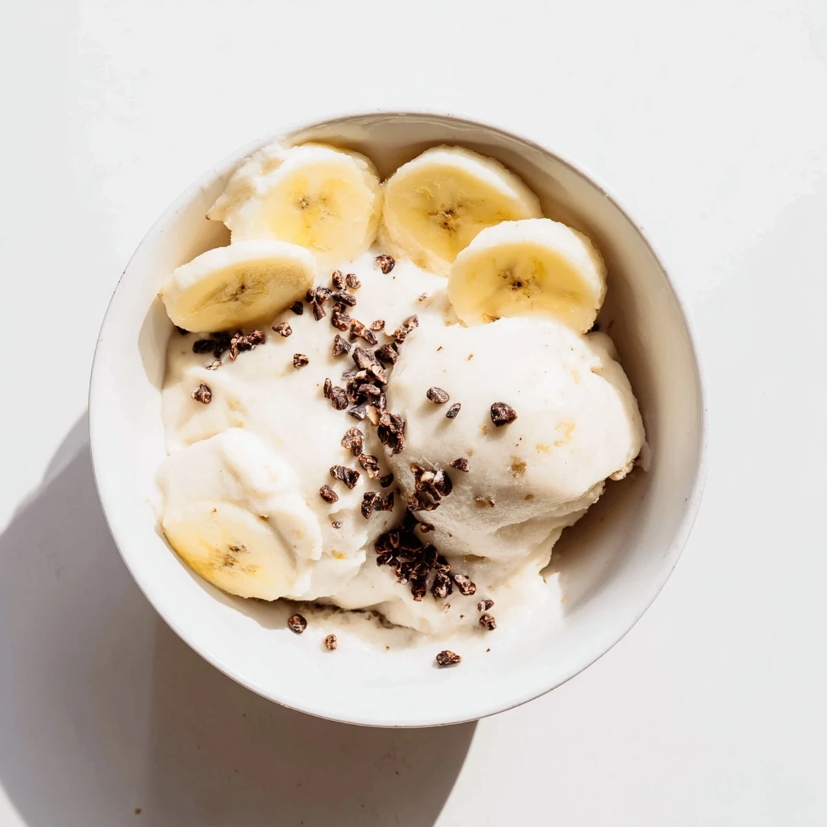 Vegan dairy-free healthy nice cream swirling in a glass bowl with vibrant berry toppings