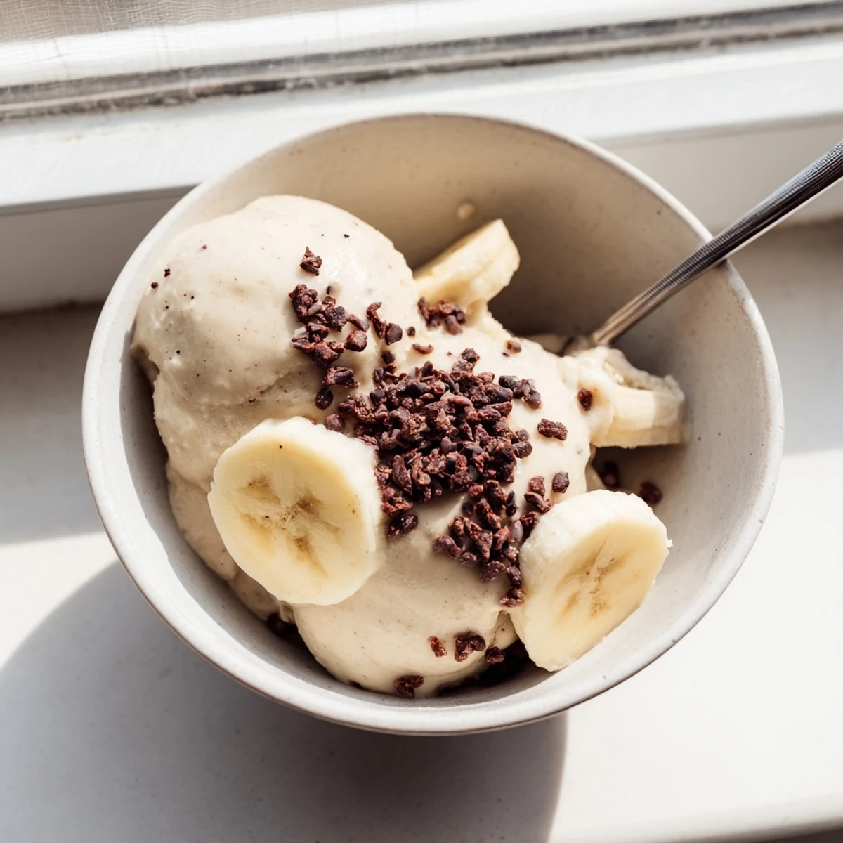 Luscious healthy nice cream served in elegant bowls with chopped nuts and cacao nibs sprinkled on top