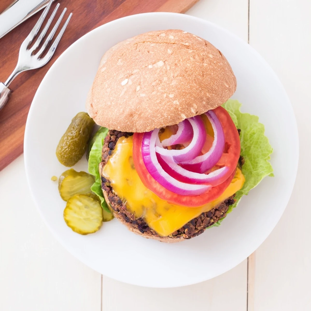Hearty black bean veggie burgers sizzling in a skillet with grill marks and melted cheese