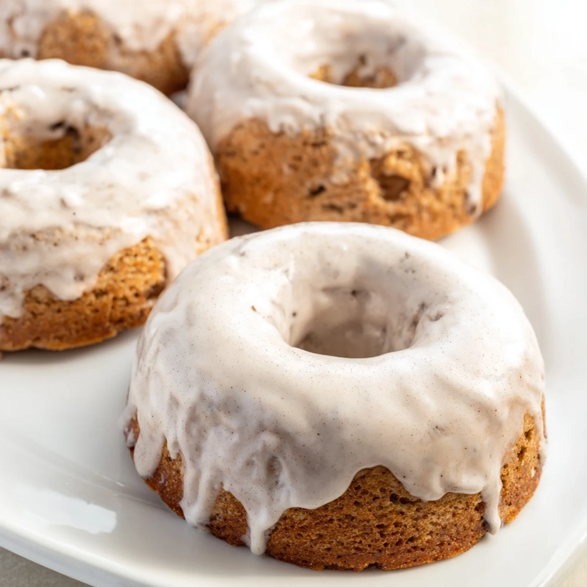 Warm banana bread donuts cooling on wire rack with powdered sugar dusting