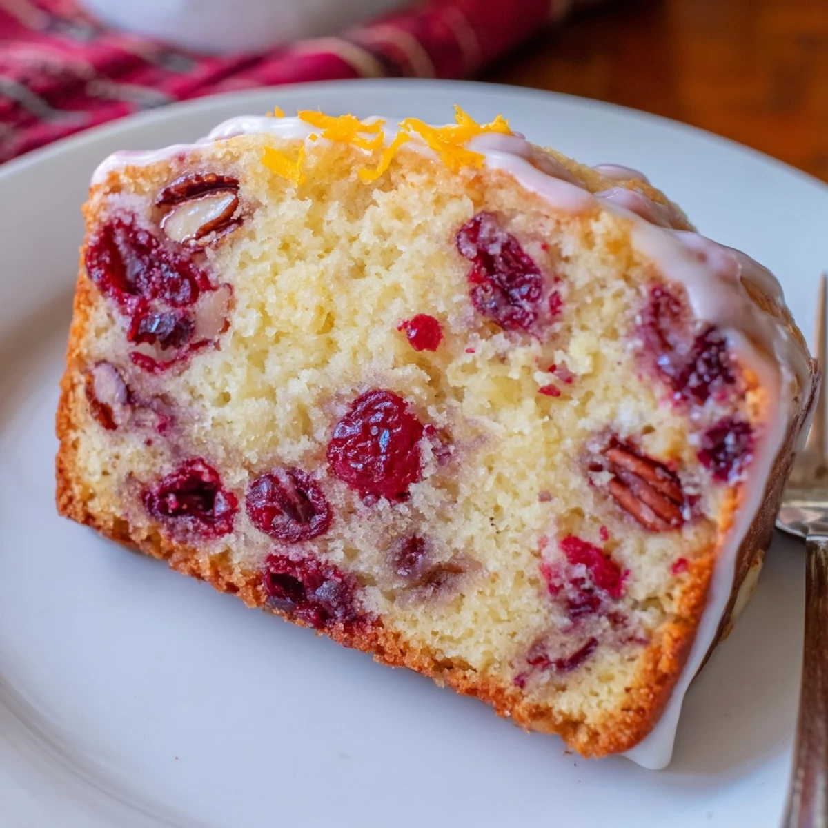 Cranberry Orange Bread warming on rack, moist slices glistening with orange glaze