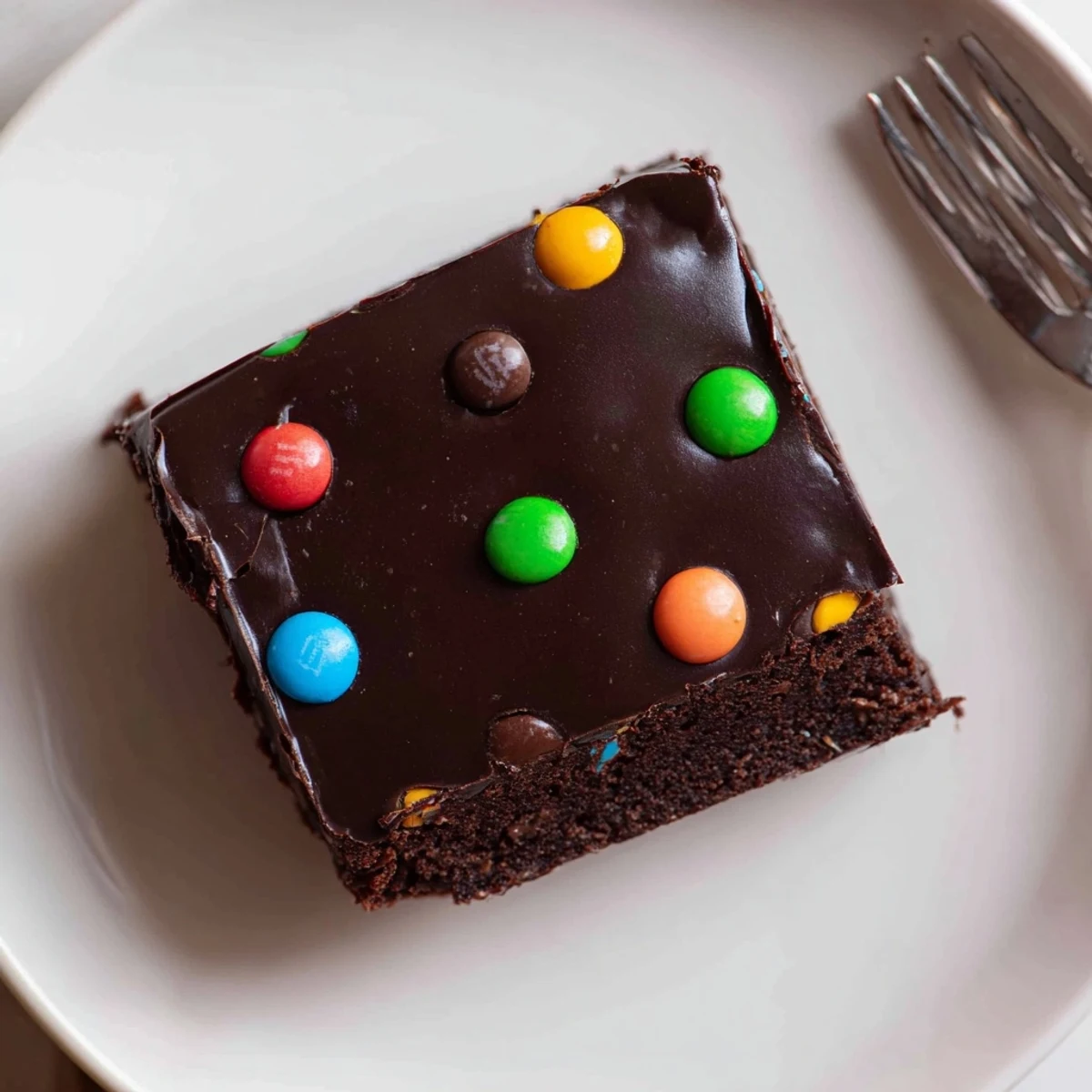 Plated Gourmet Cosmic Brownies Bars next to a chilled glass of milk.