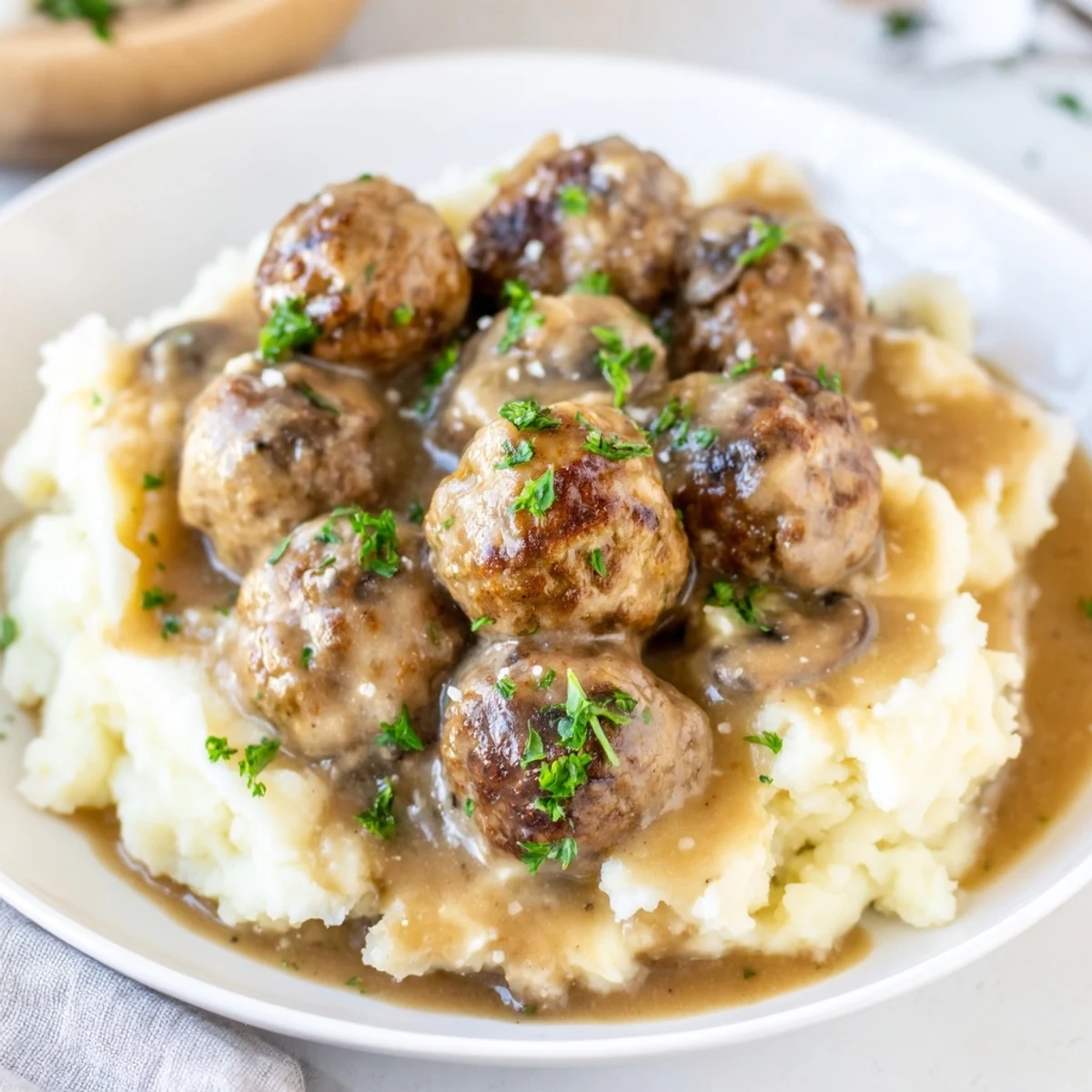 Family-style Crockpot Meatballs Gravy served over buttery mashed potatoes, steam rising