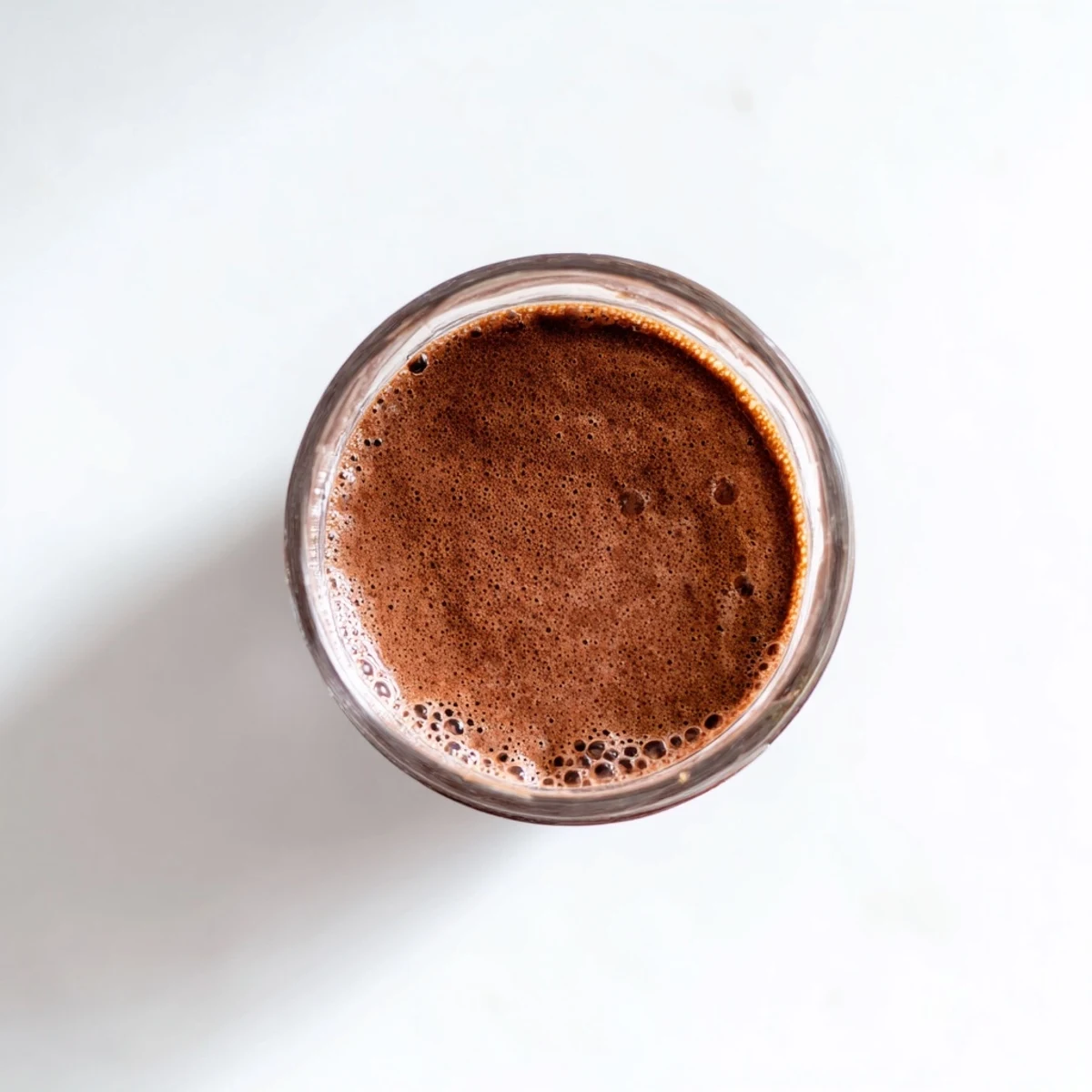 Velvety smooth raw chocolate banana shake poured into two glasses with straws