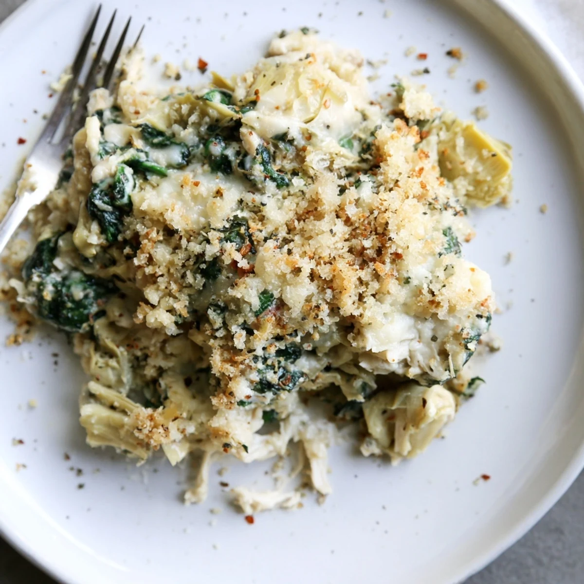 Creamy Spinach Artichoke Chicken Casserole emerging from oven with browned cheese
