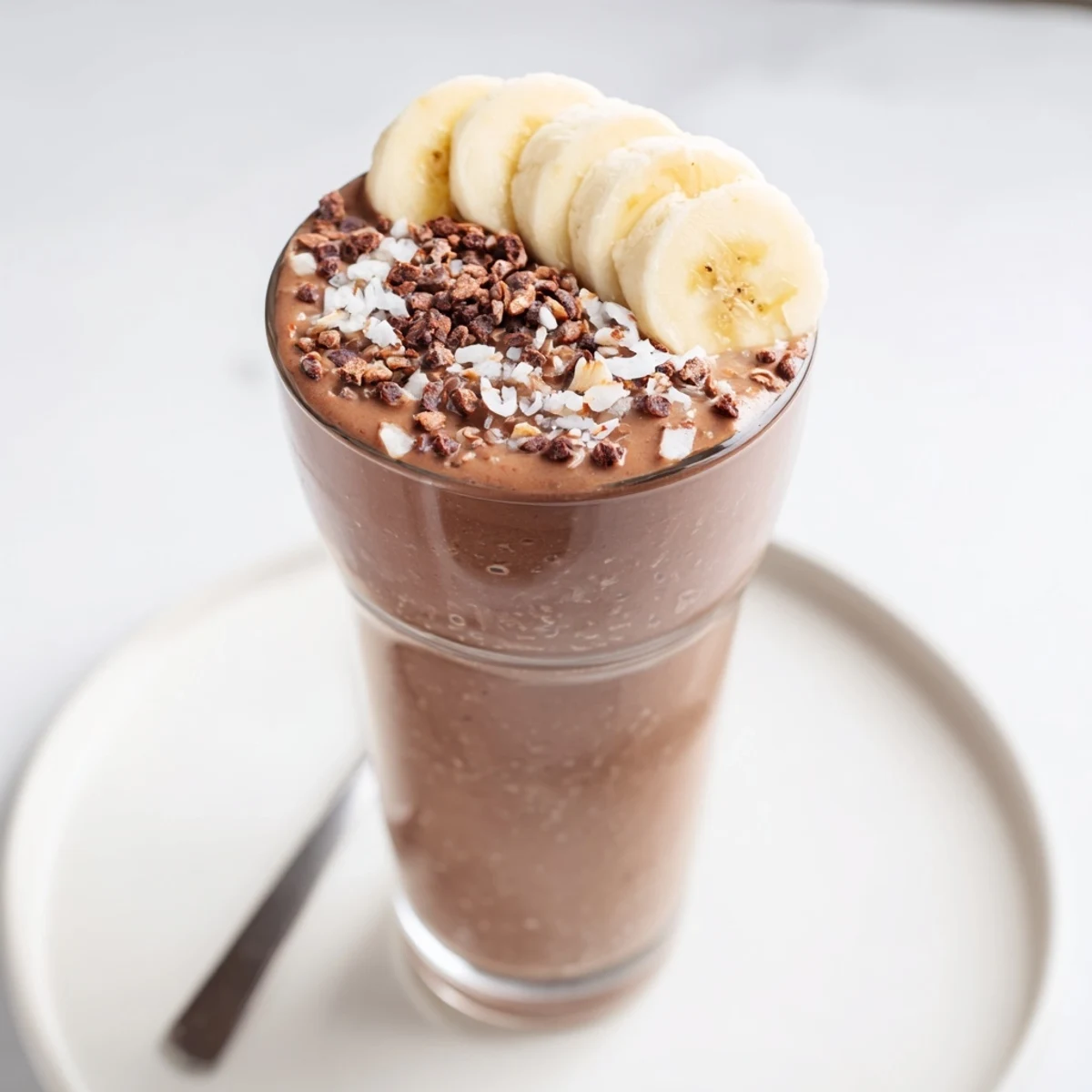 Velvety Raw Chocolate Banana Shake chilled for breakfast, garnished with cacao nibs