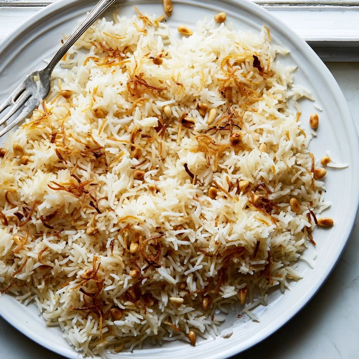 Creamy Lebanese Rice garnished with toasted pine nuts on a rustic dish