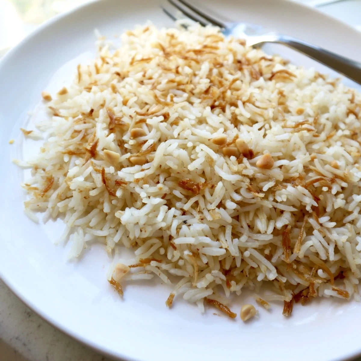Steaming plate of buttery Lebanese Rice alongside grilled chicken and vegetables