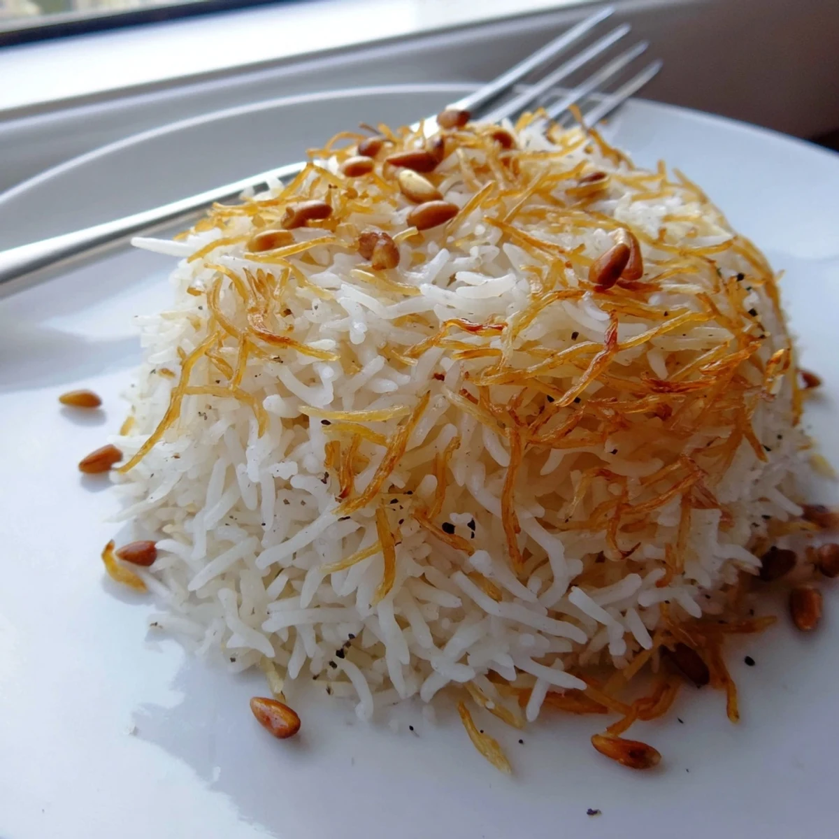 Steaming bowl of buttery Lebanese Rice garnished with crispy pine nuts and herbs