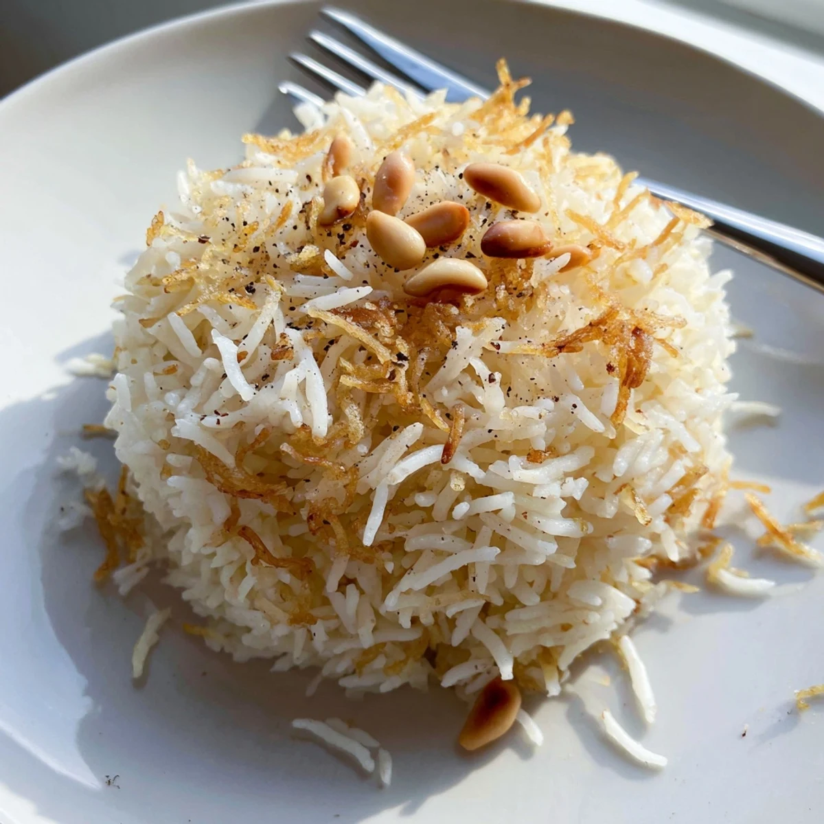 Fluffy Lebanese Rice with golden toasted vermicelli and pine nuts on a rustic plate