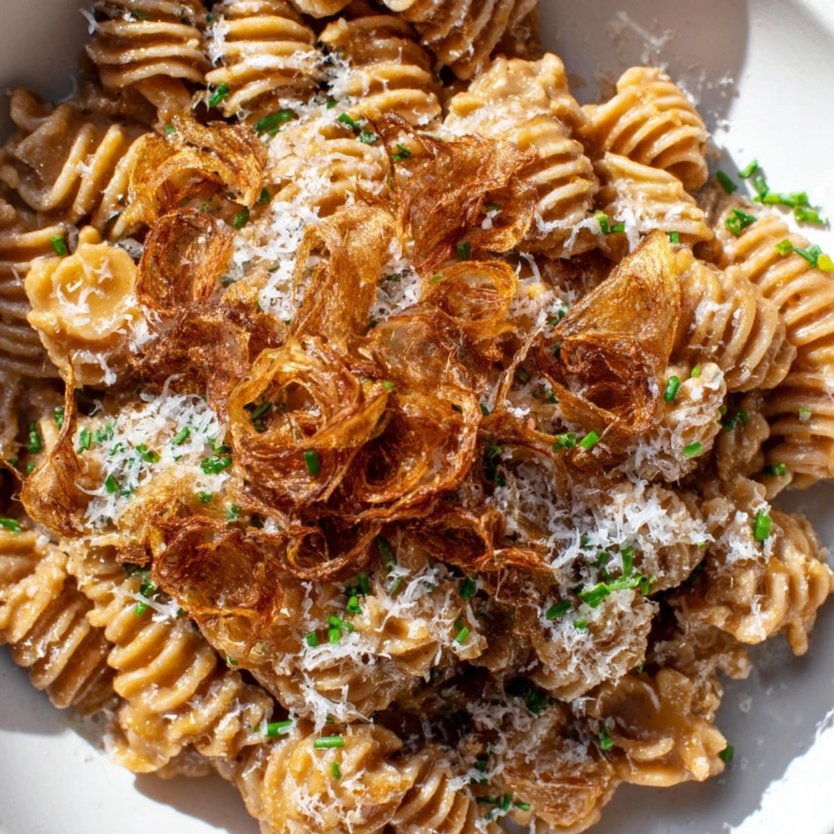 Golden brown butter miso radiatori pasta topped with crispy shallots and Parmesan