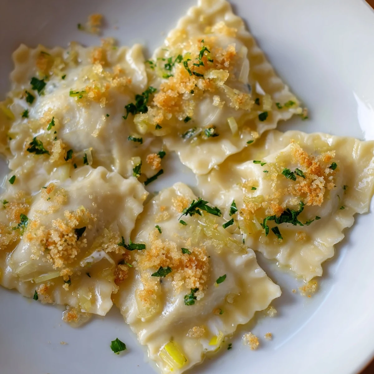 Creamy burrata-filled leek triangoli drizzled with bright lemon butter sauce on a white plate
