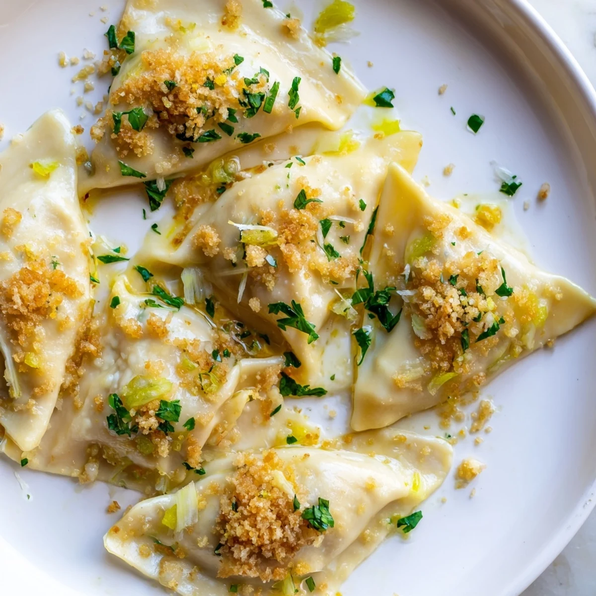 Homemade leek burrata triangoli topped with crispy golden lemon breadcrumbs served steaming hot