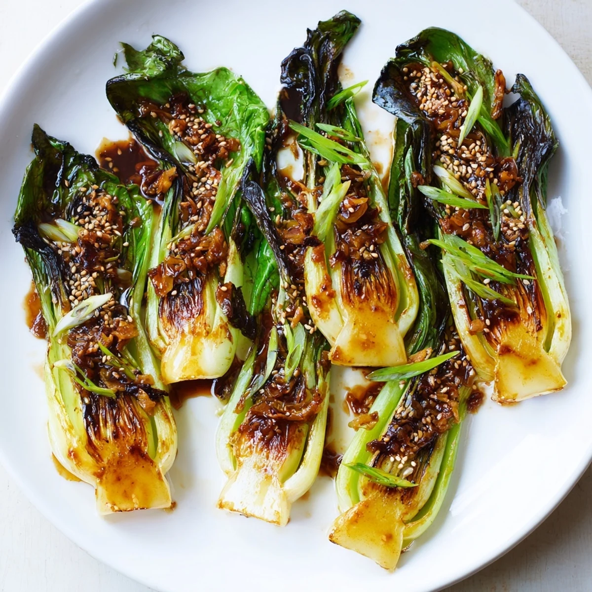 Caramelized garlic bok choy with golden seared edges on a white serving platter