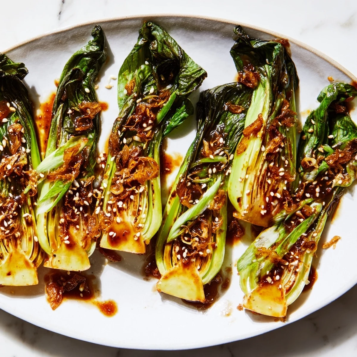 Crisp caramelized garlic bok choy in a cast iron skillet topped with sesame seeds