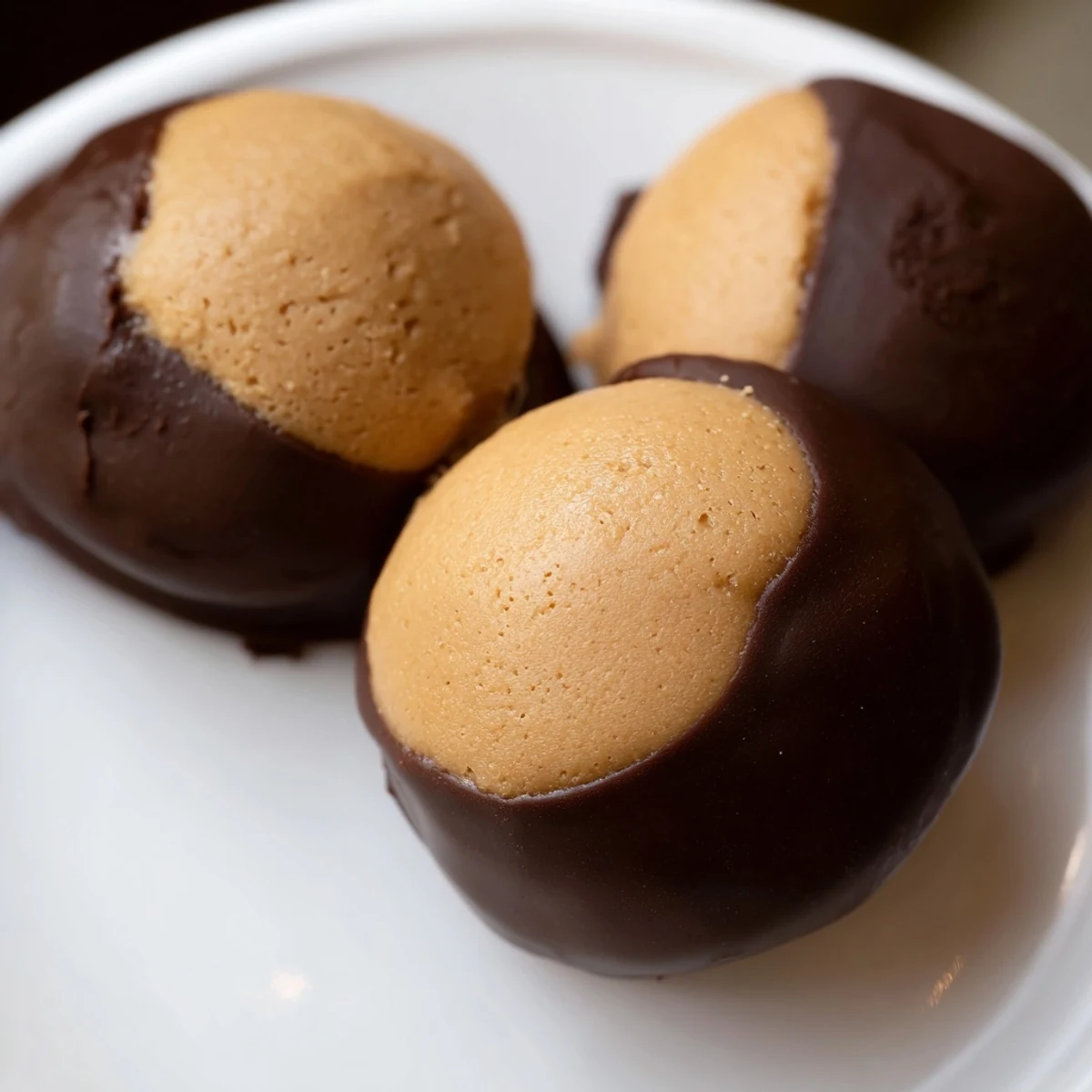 Homemade Buckeye Cookies arranged on parchment paper, each showing a classic partially dipped buckeye look