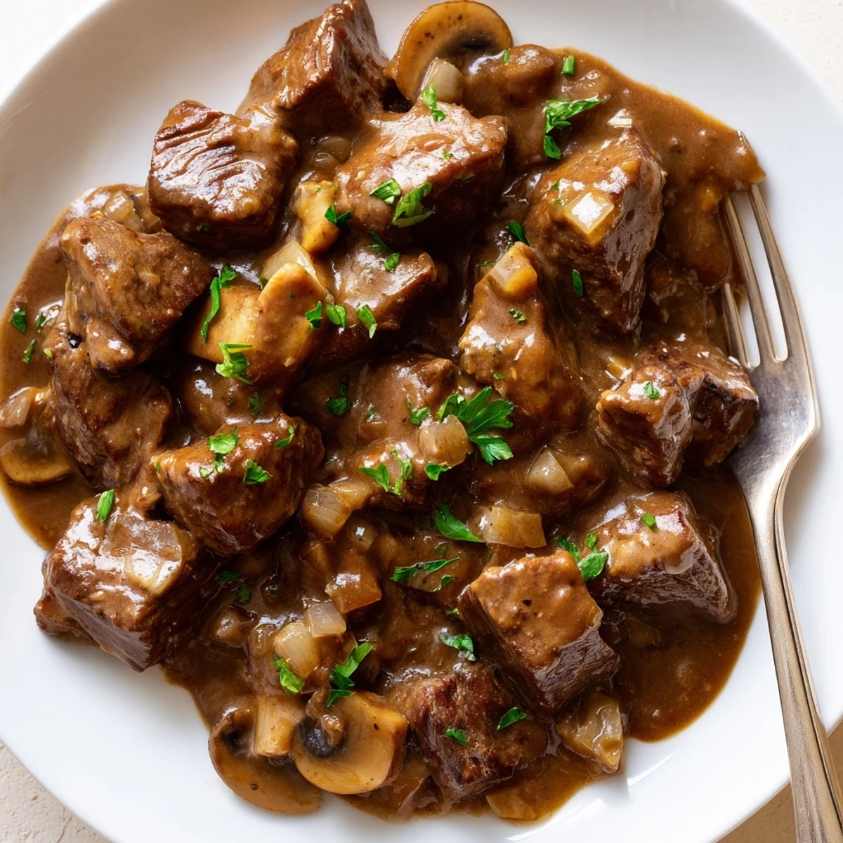 Tender weeknight steak tips and gravy served steaming hot over creamy mashed potatoes