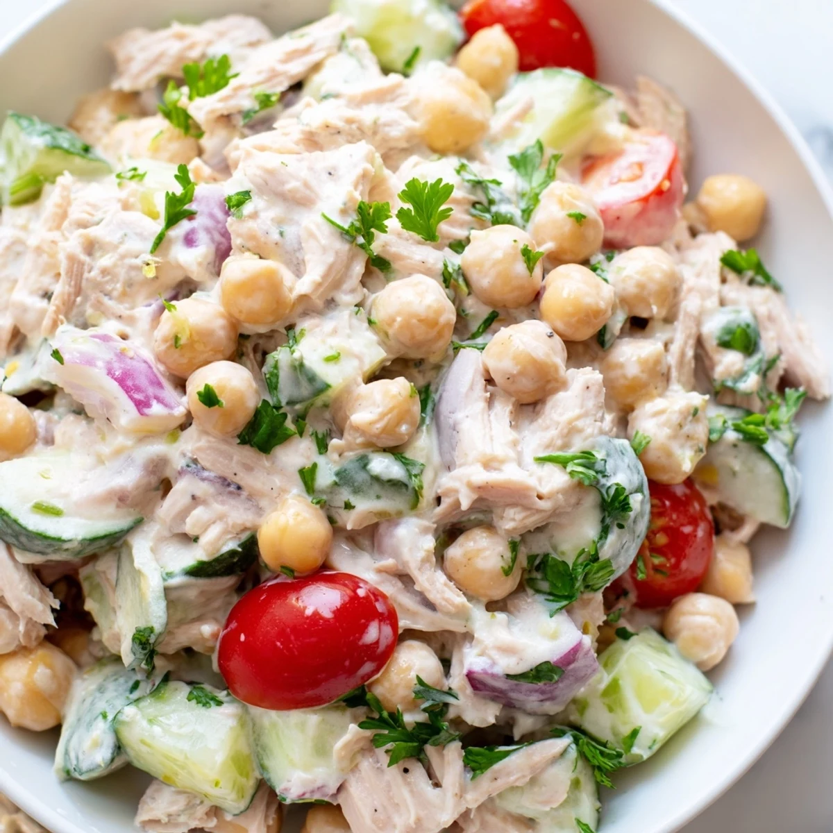 A close-up of creamy tuna chickpea cucumber salad featuring tender chickpeas, crisp cucumbers, and flaky tuna