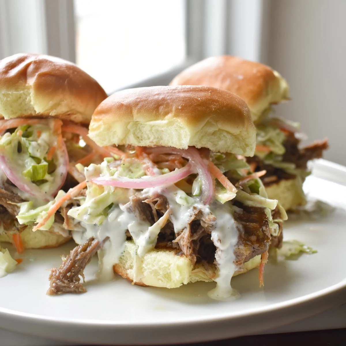 Tangy creamy Alabama white sauce pulled lamb sliders with crunchy slaw on toasted buns
