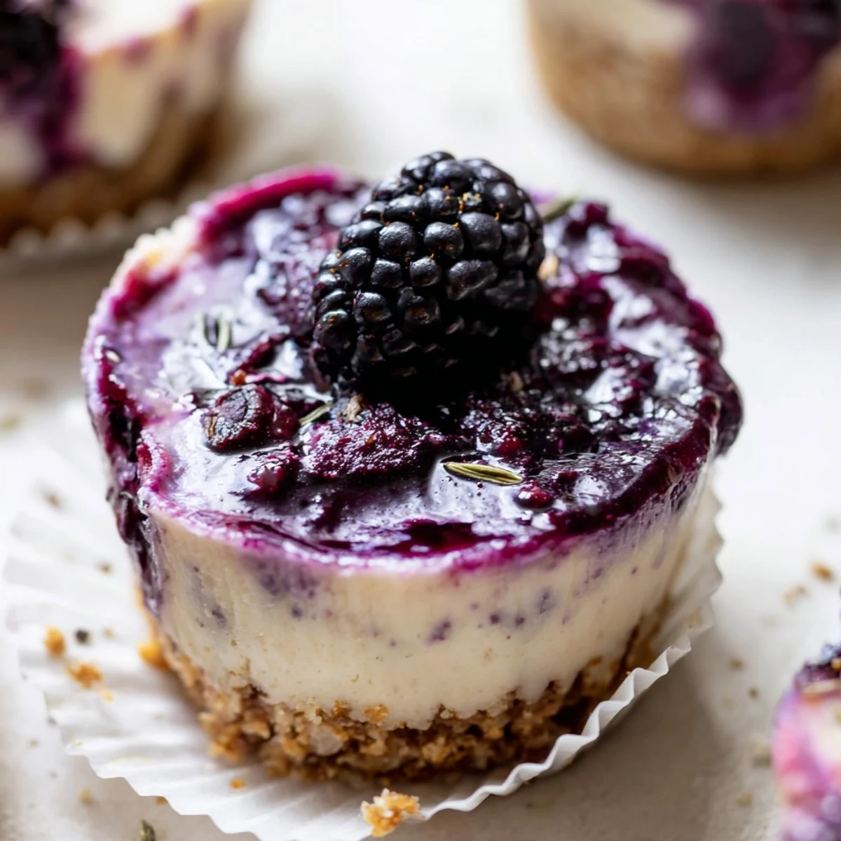 Creamy no bake mini blackberry lavender cheesecakes topped with glossy berry sauce