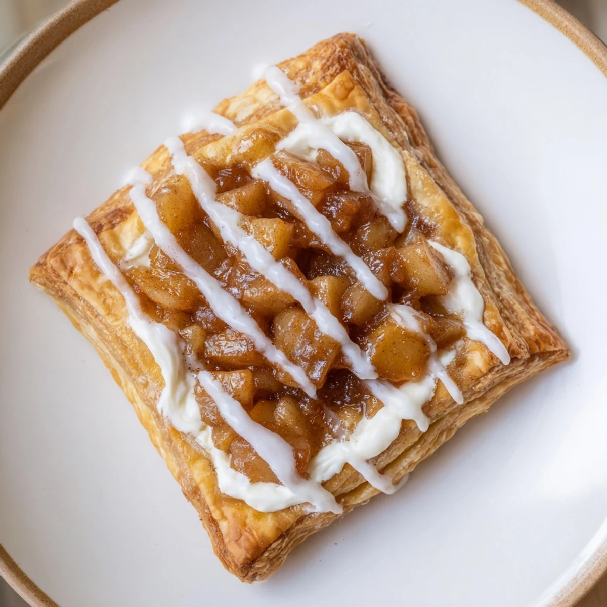 Close-up of a creamy Apple Cheese Danish on a decorative plate, perfect for a holiday brunch.