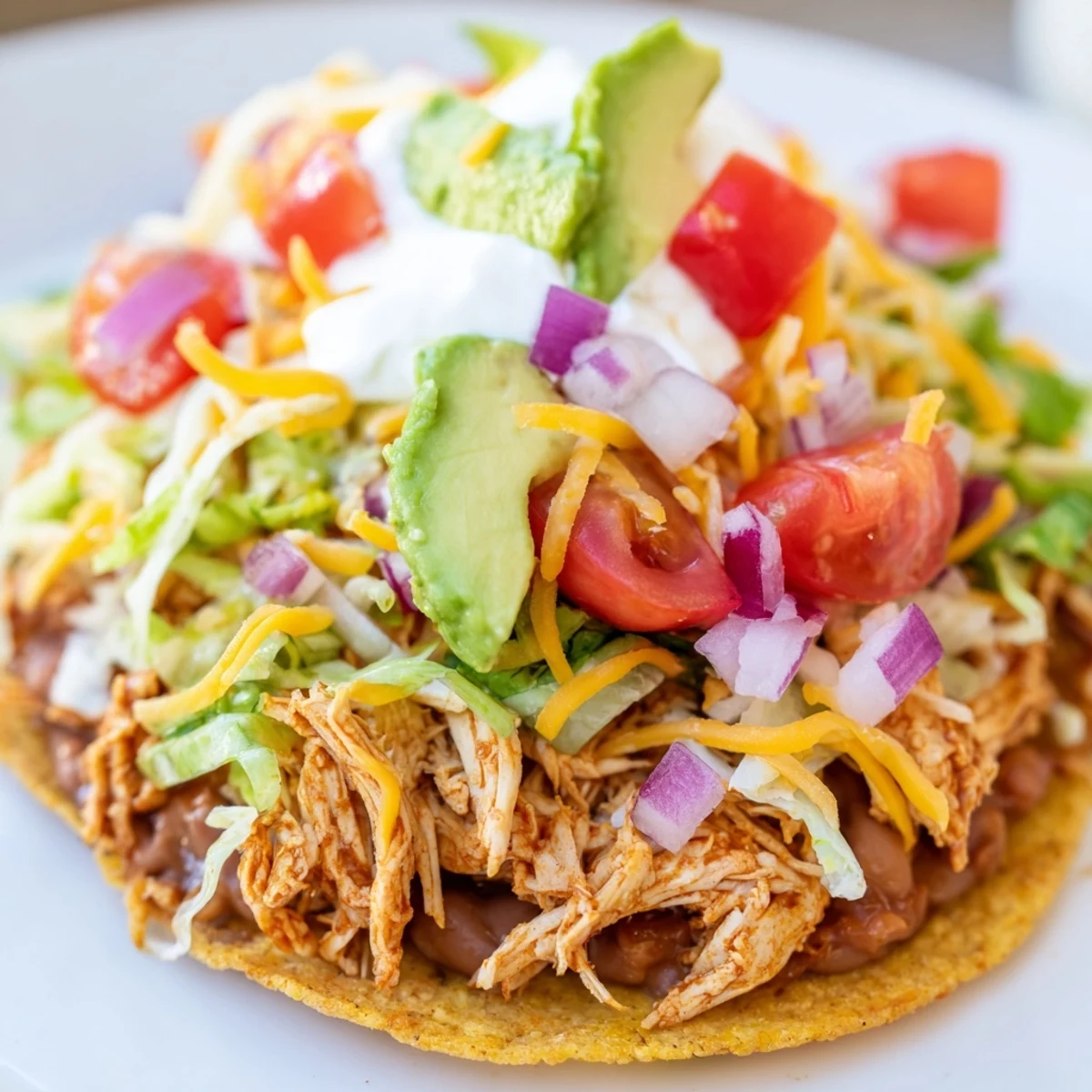 Savory Chicken Tostadas featuring zesty chicken on crunchy tortillas with avocado and cilantro