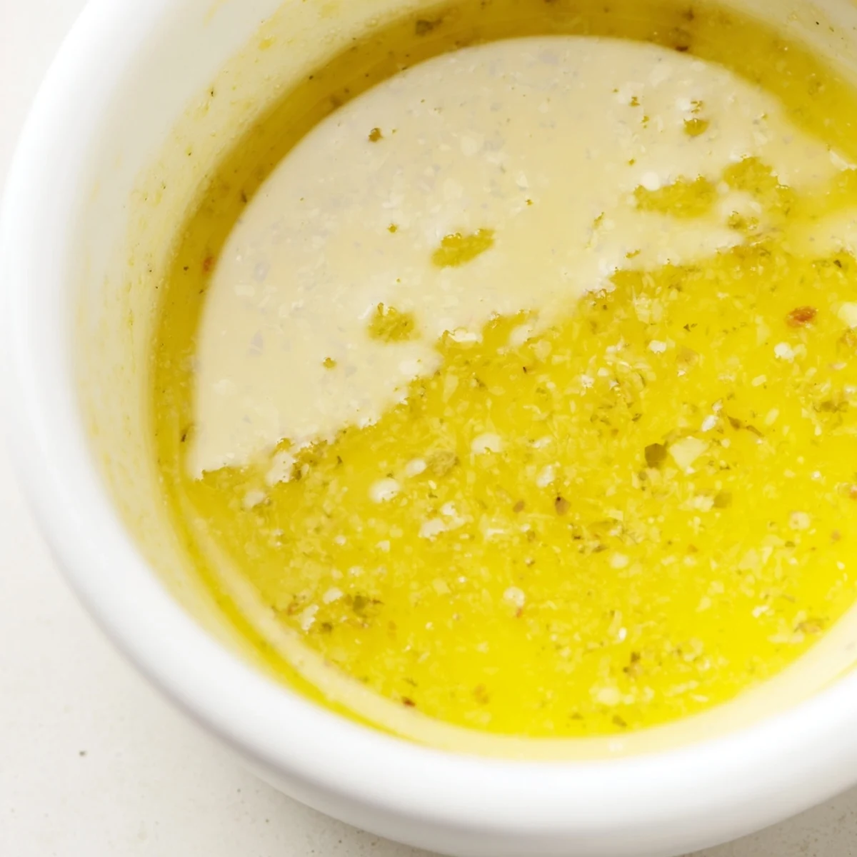 Golden lemon vinaigrette drizzled over crisp green salad with fresh herbs.  