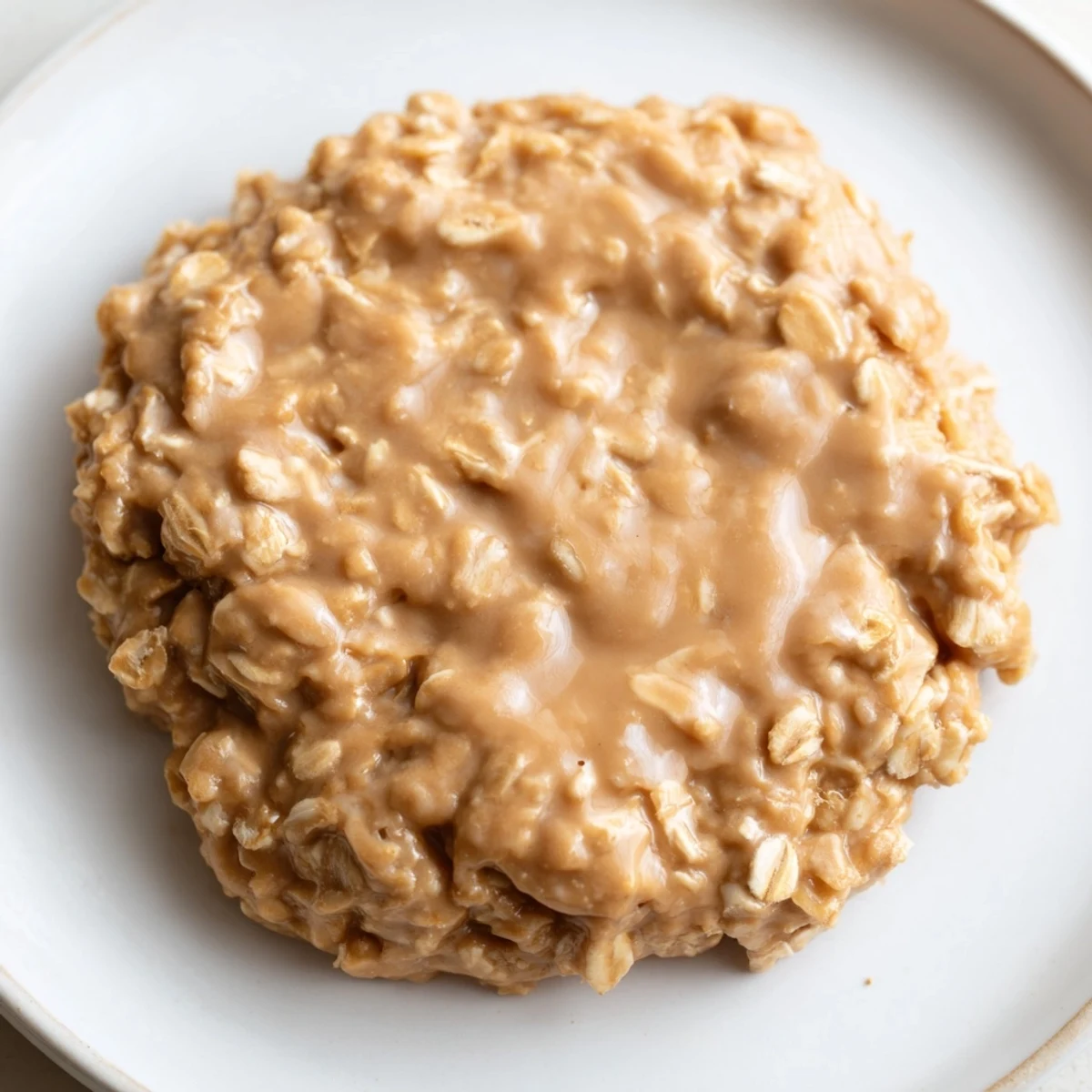 Golden peanut butter no bake cookies held in hand showing their rich texture.